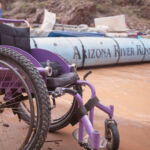 A wheelchair next to a Grand Canyon rafting motor boat