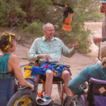 People in wheelchairs laughing while in a Grand Canyon rafting camp